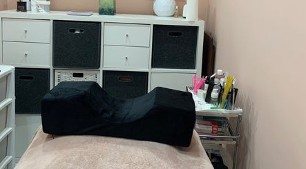 Cozy treatment room at Aura Beauty - Norbury, London, England, GB with a black cushion and organized supplies.