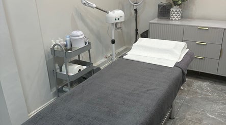 Calm treatment room at Aura Beauty - Oval, London, England, GB with a massage table and modern decor.