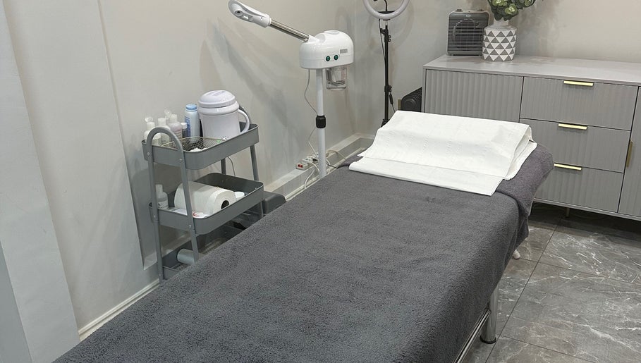 A tranquil treatment room at Aura Beauty - Oval in London, England, GB, featuring a massage table and skincare tools.