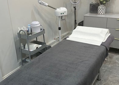 A tranquil treatment room at Aura Beauty - Oval in London, England, GB, featuring a massage table and skincare tools.