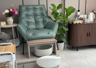Silla de manicura verde en Nail It by Karla Belandria, Ciudad de Panama, PA, rodeada de flores y plantas.