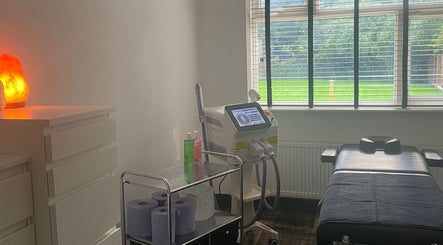 A serene treatment room at Skin Envy Laser and Aesthetics Ltd, Birmingham, England, GB with a laser machine and massage bed.