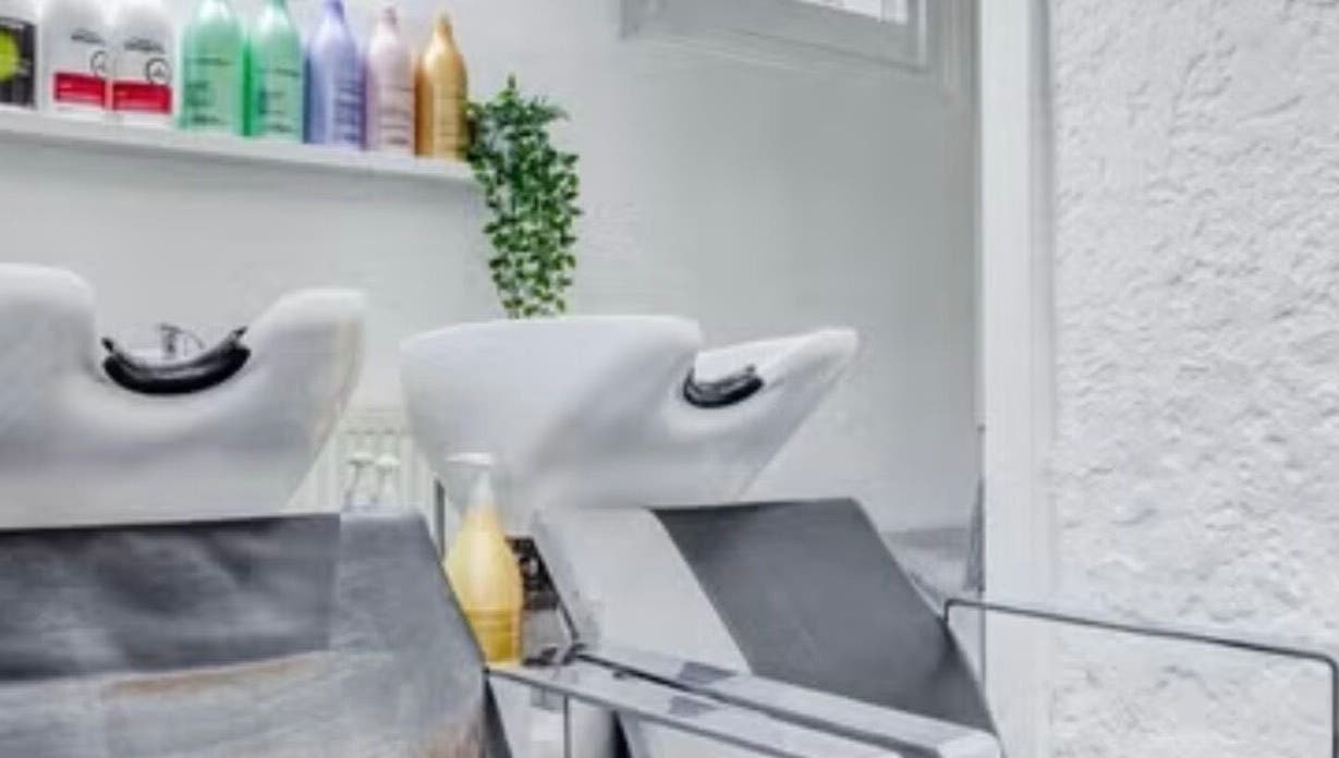 Modern wash station at Ursulabeauty.Co, London, England, GB showcasing shampoo bottles and comfortable basins.
