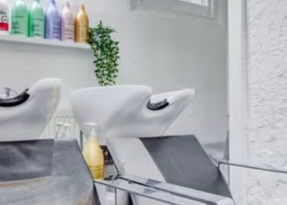 Modern wash station at Ursulabeauty.Co, London, England, GB showcasing shampoo bottles and comfortable basins.