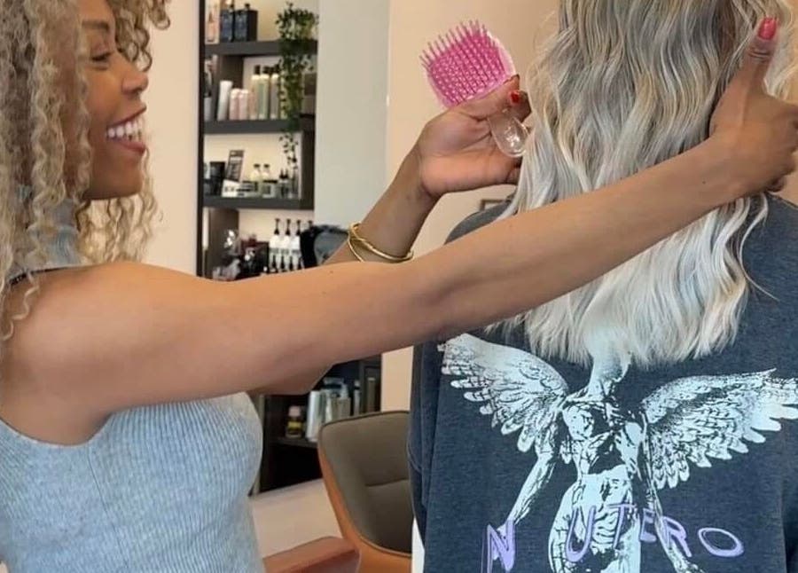 Stylist at Ursulabeauty.Co in London, England, GB creating a glamorous hairstyle with precision and care.