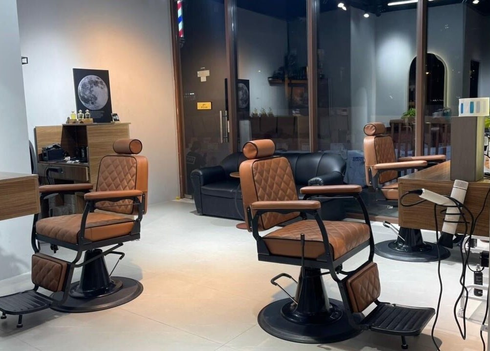 مقصورة تصفيف أنيقة في كهوف حلاقة دبي، دبي، AE تتميز بمقاعد جلدية بنية وجو فاخر.