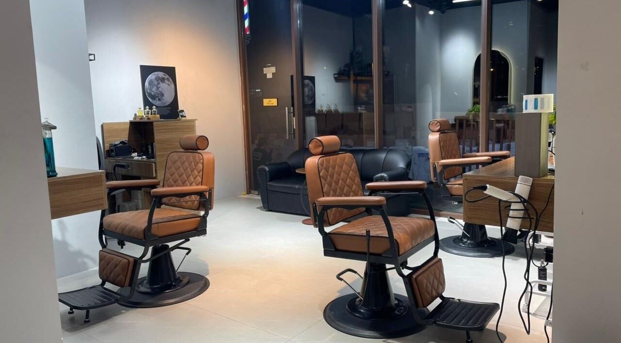 مقصورة تصفيف أنيقة في كهوف حلاقة دبي، دبي، AE تتميز بمقاعد جلدية بنية وجو فاخر.