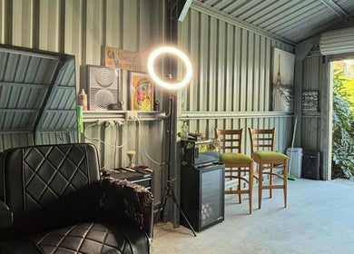 Elegant salon setup at Another Barber, Tallai, Queensland, AU with modern chairs, ring light, and wall art.