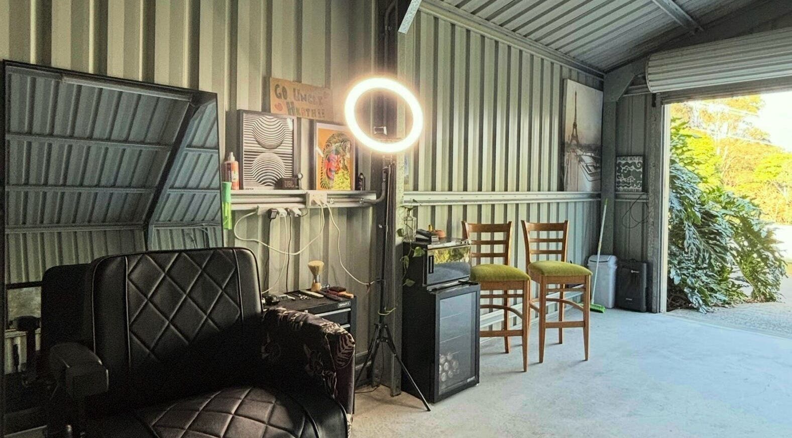 Elegant salon setup at Another Barber, Tallai, Queensland, AU with modern chairs, ring light, and wall art.