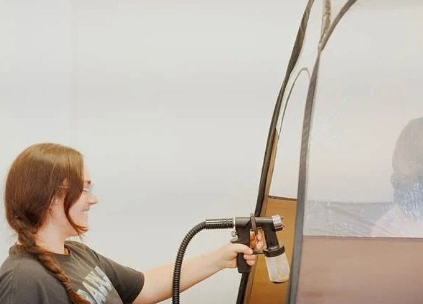 Tanning session at The House Of Calm, South Shields, England, GB. Expert applying spray for a perfect glow.