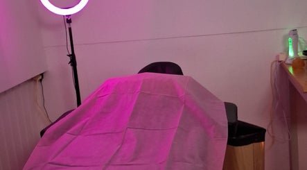 Cozy treatment room at Glow & Go in Paramaribo, Paramaribo, SR, with pink lighting and a massage table.