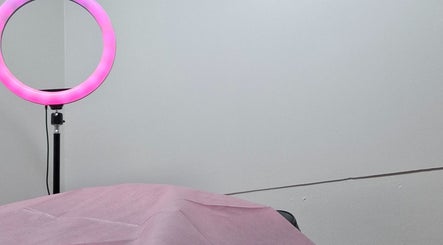 Cozy treatment room at Glow & Go, Paramaribo, Paramaribo, SR with pink ring light ambiance.