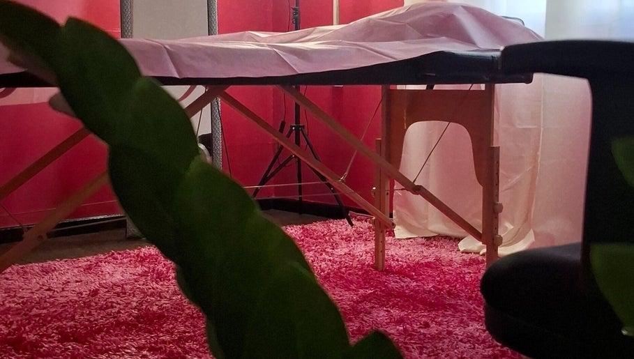 Cozy treatment room at Glow & Go, Paramaribo, Paramaribo, SR, featuring a massage table and pink decor.