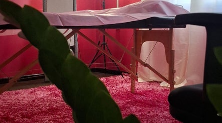 Cozy treatment room at Glow & Go, Paramaribo, Paramaribo, SR, featuring a massage table and pink decor.