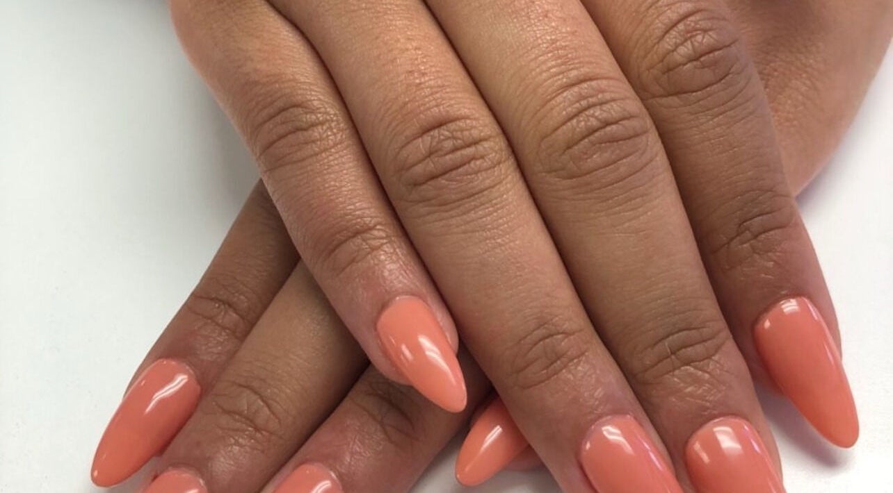 Elegant peach manicure at Narineh in Burbank, California, US showcasing glossy, pointed nails.