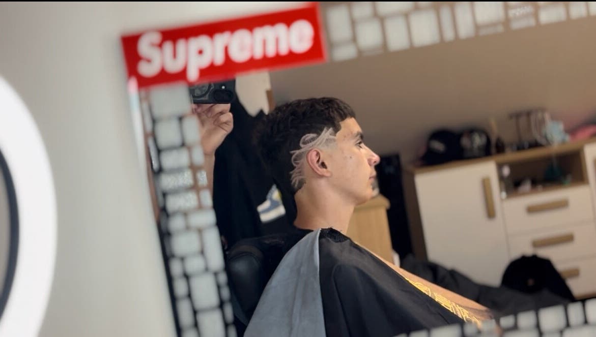 Client with trendy haircut at TomasCutzz_ salon, reflected in mirror, Český Krumlov, Jihočeský Kraj, CZ.