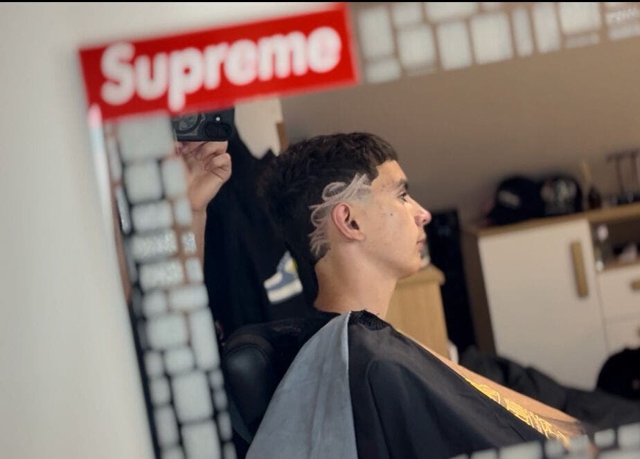 Client with trendy haircut at TomasCutzz_ salon, reflected in mirror, Český Krumlov, Jihočeský Kraj, CZ.