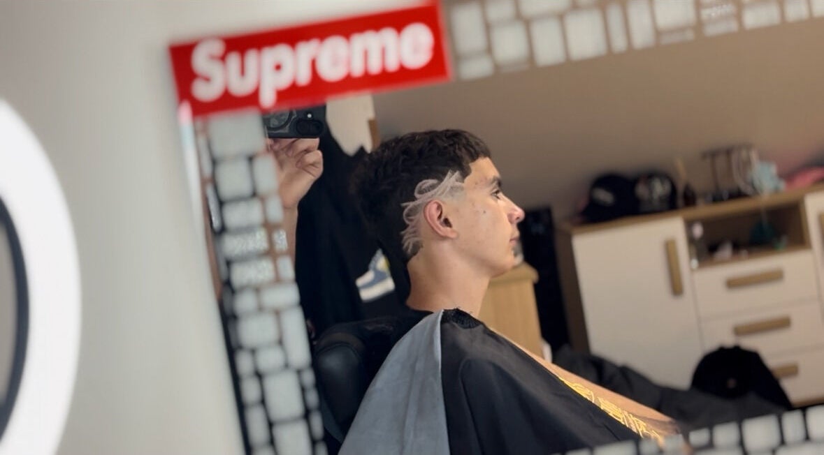 Client with trendy haircut at TomasCutzz_ salon, reflected in mirror, Český Krumlov, Jihočeský Kraj, CZ.