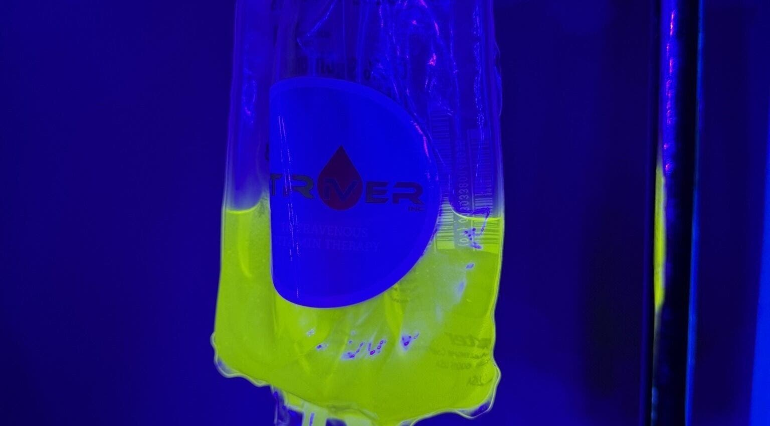 Vibrant IV bag at Striver IV Vitamin Infusion, Chicago, Illinois, US under blue light.