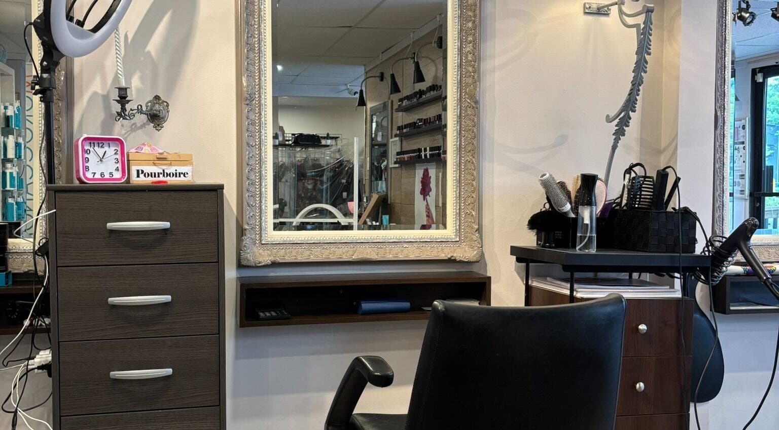 Station coiffure élégante chez Nara Coiffure à Saint-Hubert, Québec, CA, avec miroir encadré et outils de beauté.