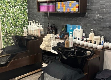 Espace de coiffure Nara Coiffure à Saint-Hubert, Québec, CA, avec produits de soin capillaire sur étagères.