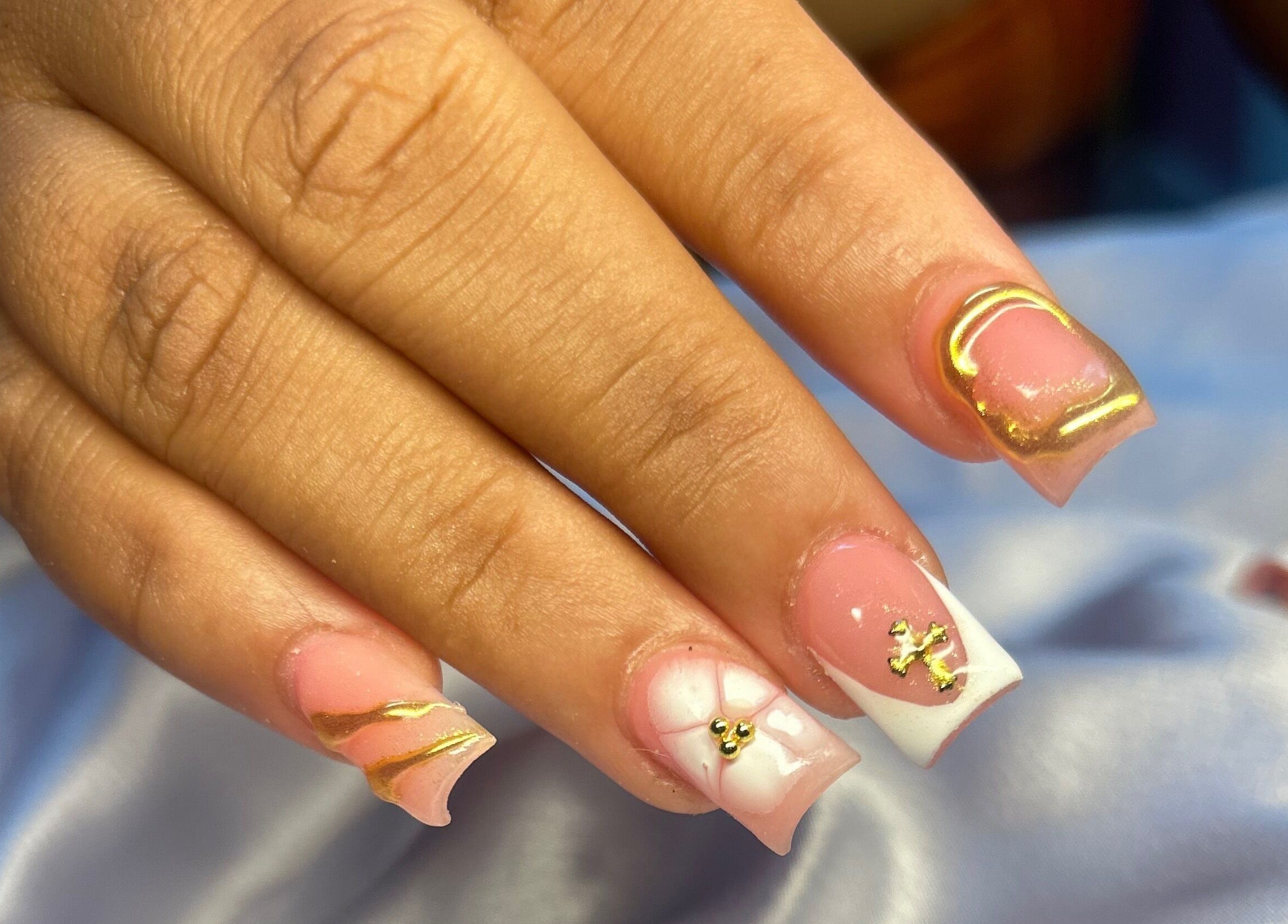 Close-up of elegant gold-accented nails at TNP Salon, Nassau, New Providence, BS.
