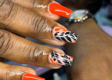 Stylish nail art with orange and black design at TNP Salon, Nassau, New Providence, BS.
