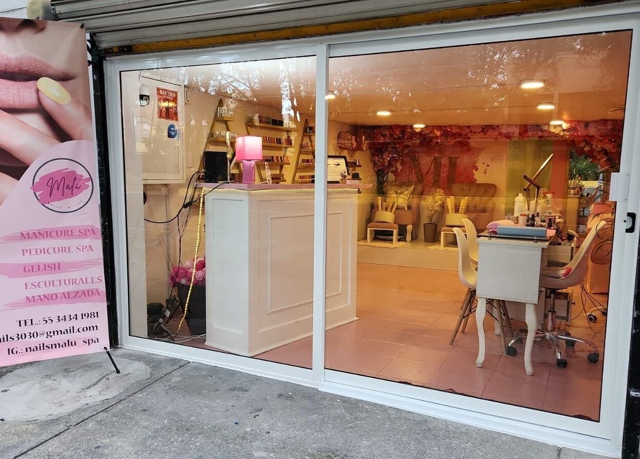 Entrada de Malú Nails&Spa, Ciudad De México, decorada con cartel publicitario de manicura y spa.
