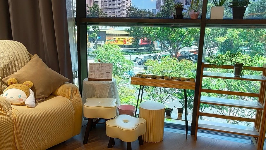Cozy seating area with a plush chair and plants at Velveté Boutique, offering a view of Singapore, Singapore, SG.