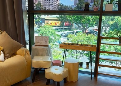 Cozy seating area with a plush chair and plants at Velveté Boutique, offering a view of Singapore, Singapore, SG.