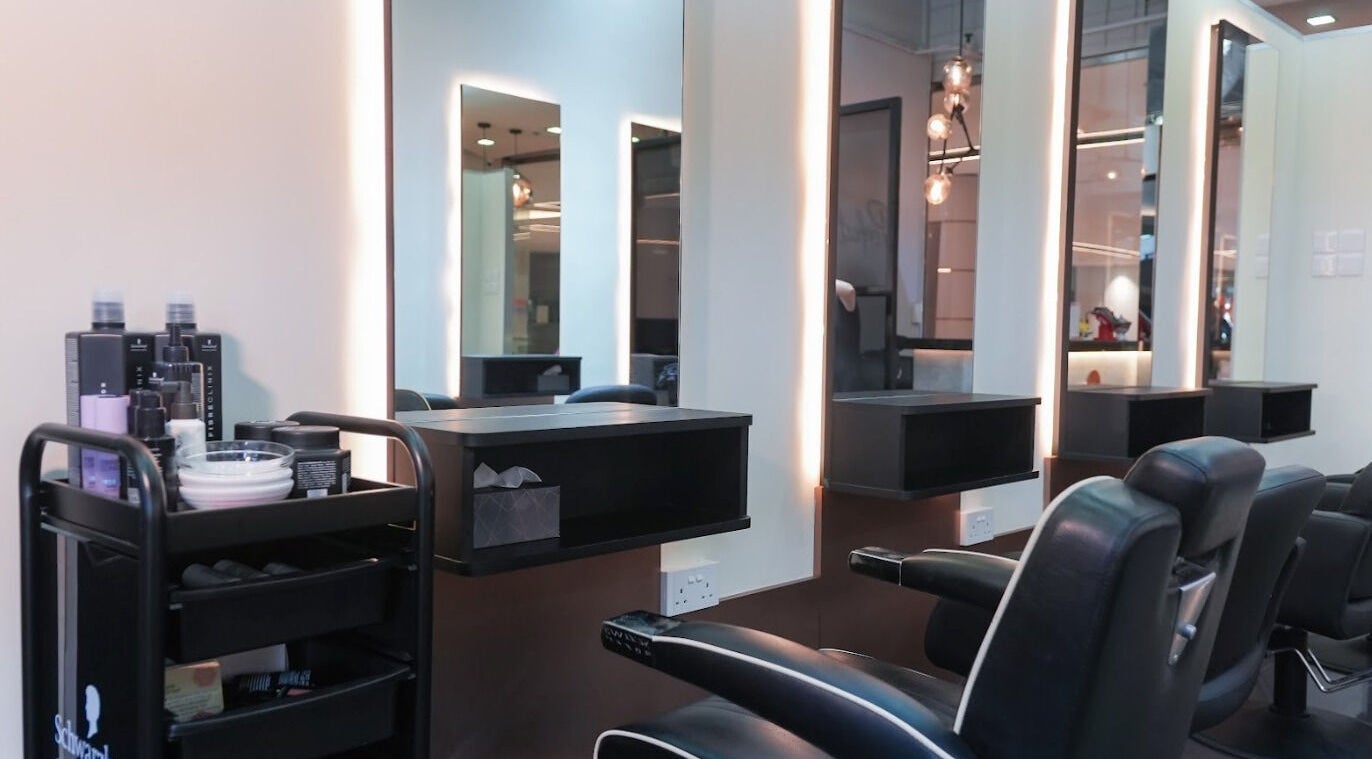 Spacious, modern salon at Perfect Style Salon, Singapore, SG with sleek black chairs and illuminated mirrors.