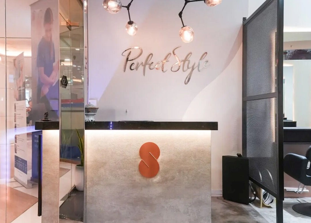 Elegant reception desk at Perfect Style Salon, Singapore, SG with modern lighting and decor.