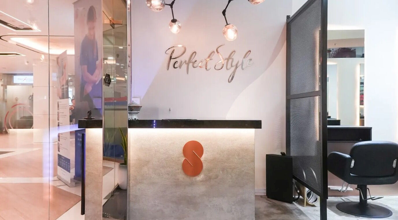Elegant reception desk at Perfect Style Salon, Singapore, SG with modern lighting and decor.