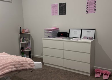 Relaxing treatment room at Brat Studio, Tahmoor, New South Wales, AU with soft pink accents and certification display.