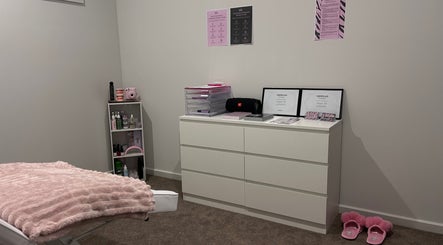 Relaxing treatment room at Brat Studio, Tahmoor, New South Wales, AU with soft pink accents and certification display.