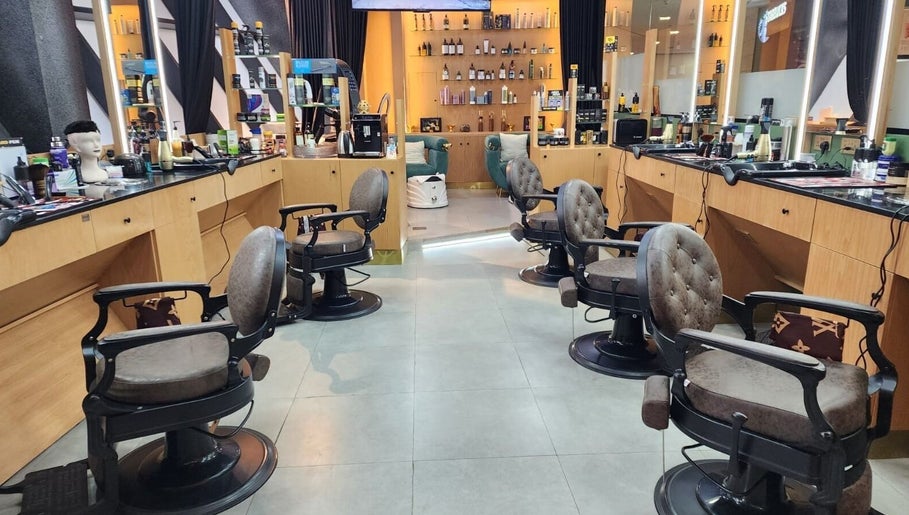 Modern seating area at Slon Street salon, Abu Dhabi, AE, featuring stylish mirrors and plush chairs.