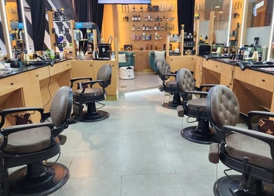 Modern seating area at Slon Street salon, Abu Dhabi, AE, featuring stylish mirrors and plush chairs.