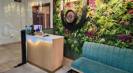 Reception area at Slon Street Abu Dhabi, AE with vibrant plant wall and elegant seating.