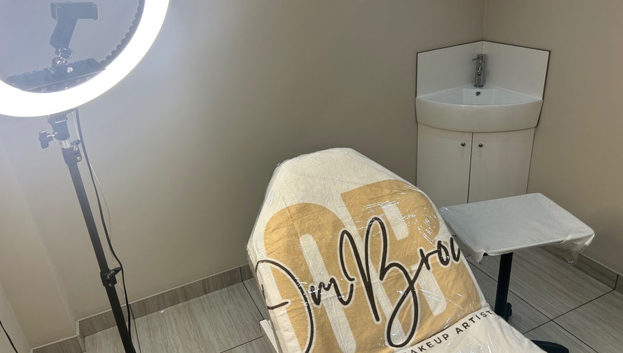 Professional beauty treatment chair at OMBrow, Birmingham, England, GB with soft lighting and a sink.
