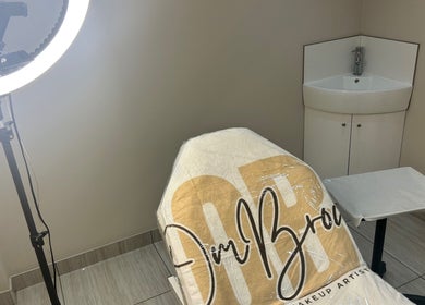 Professional beauty treatment chair at OMBrow, Birmingham, England, GB with soft lighting and a sink.