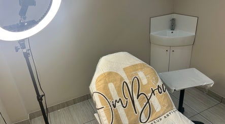 Professional beauty treatment chair at OMBrow, Birmingham, England, GB with soft lighting and a sink.