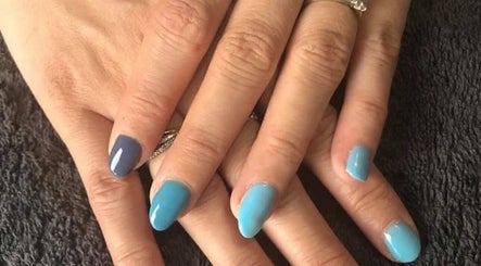 Elegant blue manicure at Polished Nails & Beauty, Worcester, England, GB. Perfectly polished nails on a black towel.
