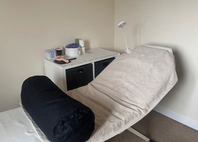 Cozy treatment room at Polished Nails & Beauty, Worcester, GB, featuring a comfortable massage bed.