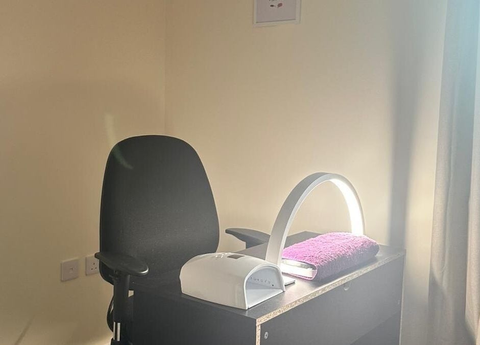 Polished Nails & Beauty's cozy nail station in Worcester, GB, with a sleek lamp and plush chair.