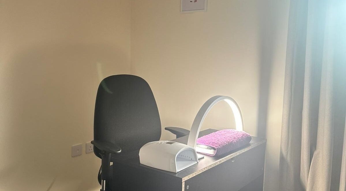 Polished Nails & Beauty's cozy nail station in Worcester, GB, with a sleek lamp and plush chair.