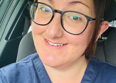 Smiling person in car wearing glasses, representing Bamber Aesthetic Solutions, Slyne, England, GB.