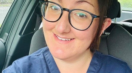 Smiling person in car wearing glasses, representing Bamber Aesthetic Solutions, Slyne, England, GB.