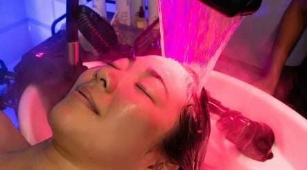 Relaxing facial treatment at MMSTUDIO | Korean Biotech Face & Scalp Programs in London, England, GB under pink light.