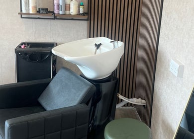 Stylish hair wash station at AZ Hair Salon, Southport, England, GB. Modern design with black chair and products.