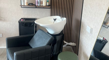 Stylish hair wash station at AZ Hair Salon, Southport, England, GB. Modern design with black chair and products.